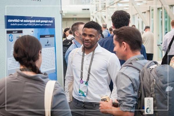 Group of people around a poster presentation